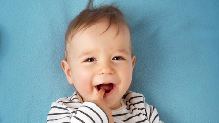 Toddler giggling with finger in mouth