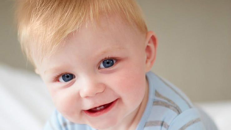 Blonde baby boy smiling at camera