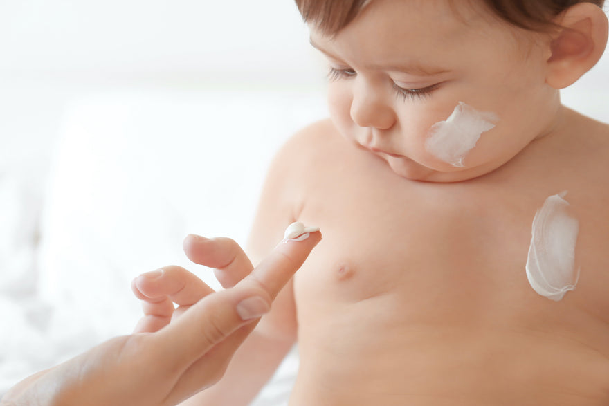 Mom applying cream to baby's face