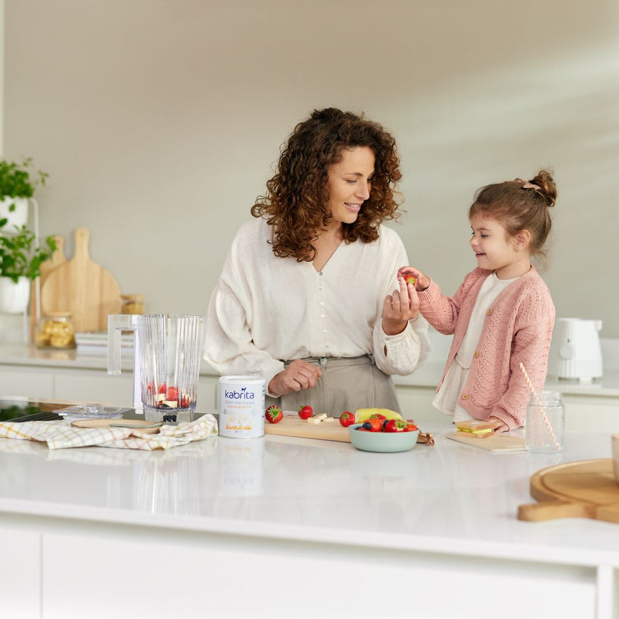 Mother and daughter making a strawberry smoothie